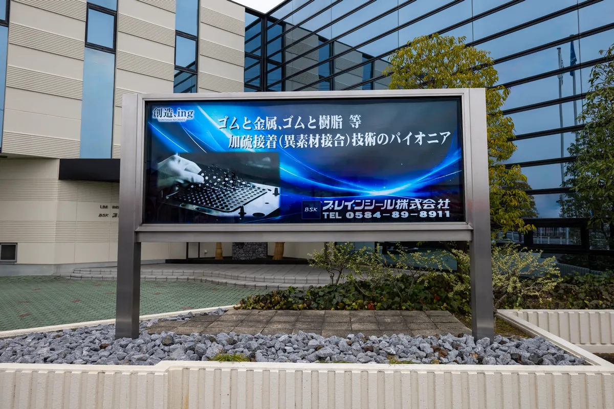 日差しに照らされた、ブレインシールの社名ロゴ看板。本社入り口の様子。